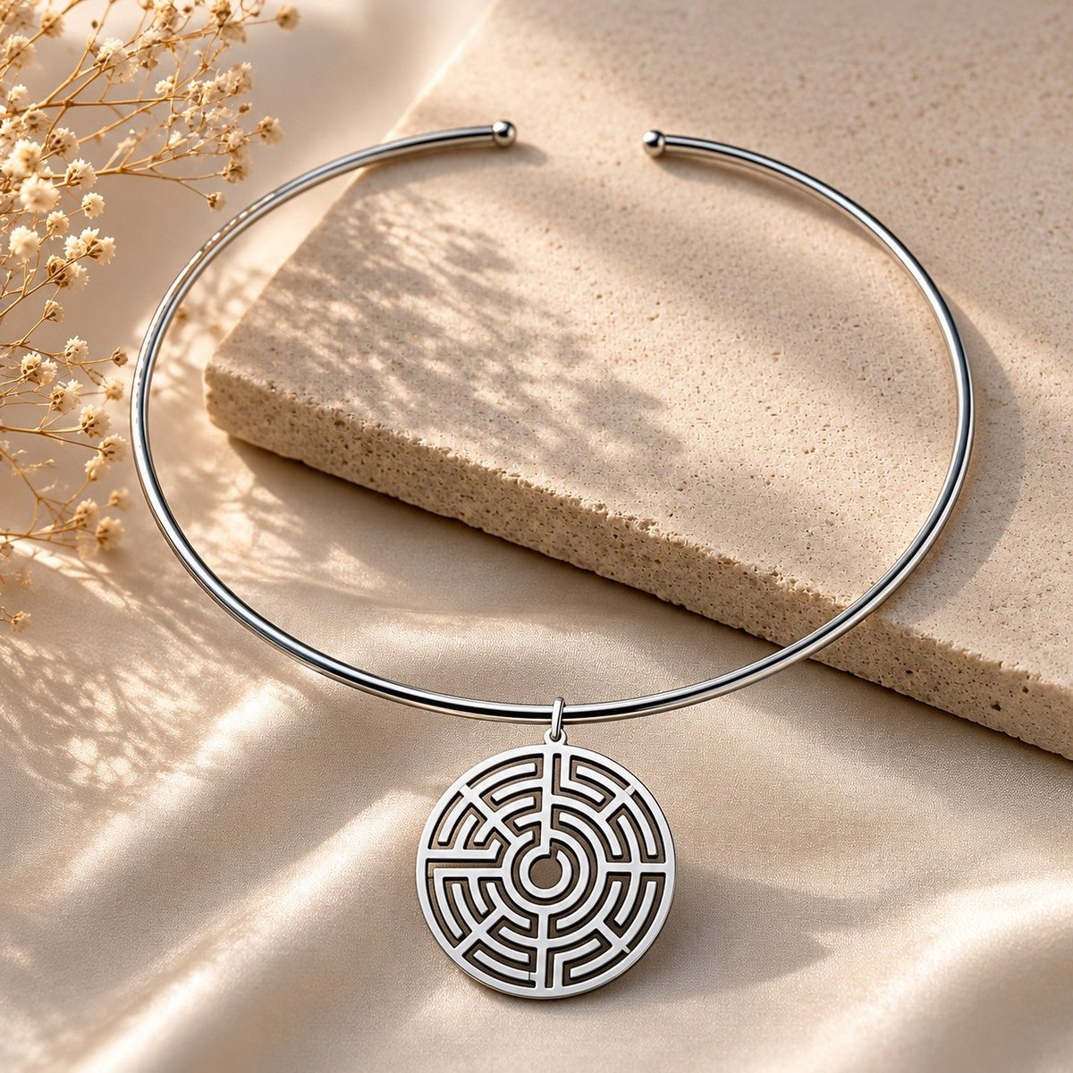 Sterling silver labyrinth disc pendant with cut-out maze design, shown hanging on a silver choker