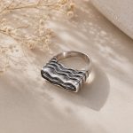 Sculptural sterling silver ring with layered wave motif in polished and oxidized finishes