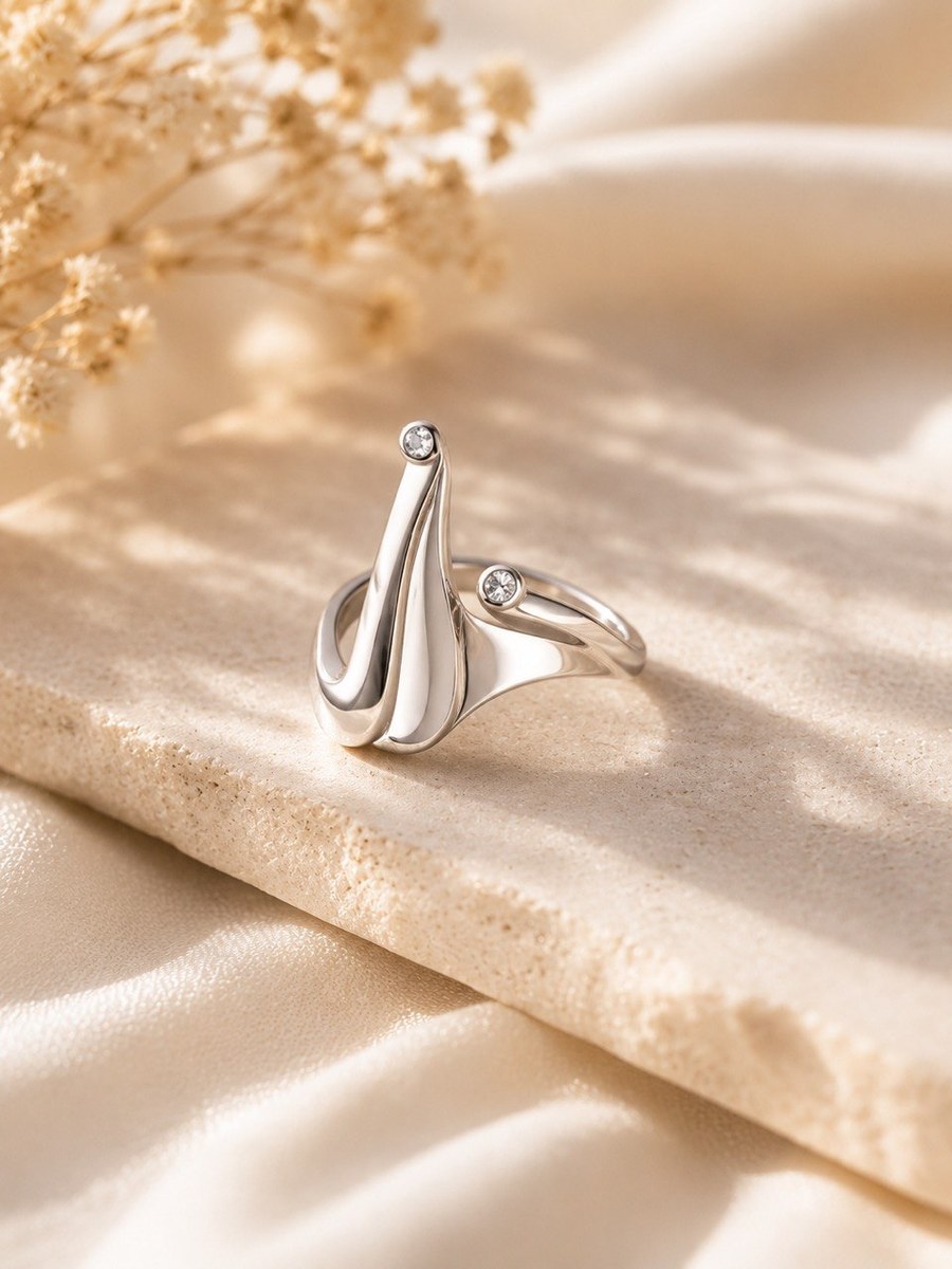 Sculptural sterling silver ring with flowing flame-like lines and two small cubic zirconia stones