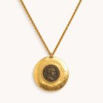 Hammered gold-tone medallion pendant framing an antiqued Roman-emperor coin reproduction, on a textured gold-tone chain